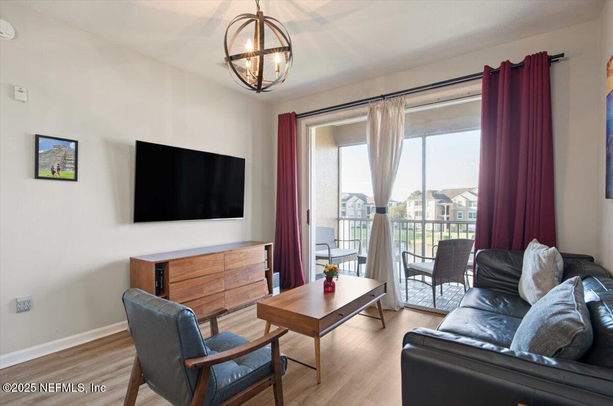 7990 Baymeadows Road East, Unit 913 Jacksonville, FL 32256 - Photo 12 of 70 a living room with furniture a flat screen tv and a large window