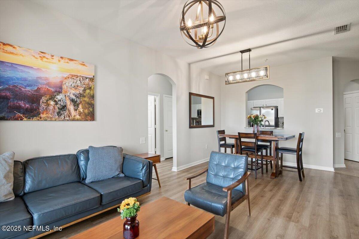 7990 Baymeadows Road East, Unit 913 Jacksonville, FL 32256 - Photo 13 of 70 a living room with furniture a dining table and wooden floor