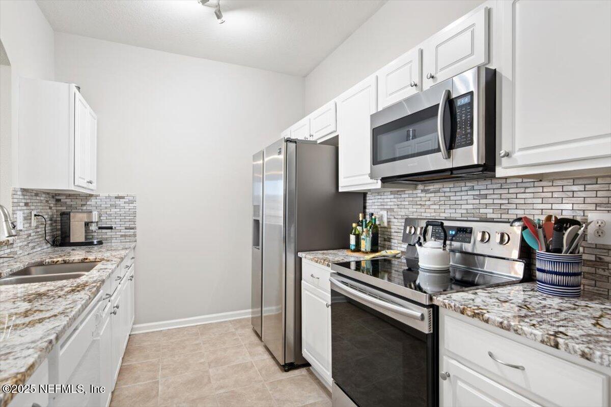 7990 Baymeadows Road East, Unit 913 Jacksonville, FL 32256 - Photo 16 of 70 a kitchen with stainless steel appliances granite countertop a sink stove and refrigerator