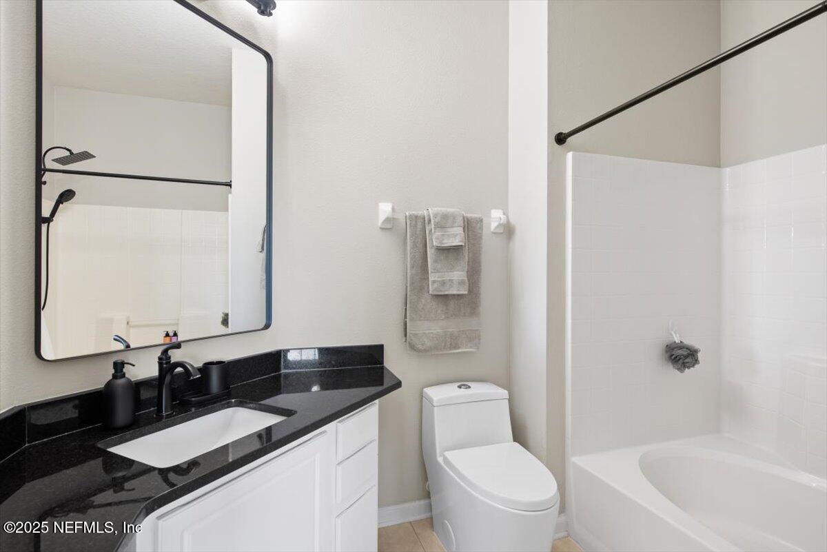 7990 Baymeadows Road East, Unit 913 Jacksonville, FL 32256 - Photo 29 of 70 a bathroom with a granite countertop sink toilet and shower