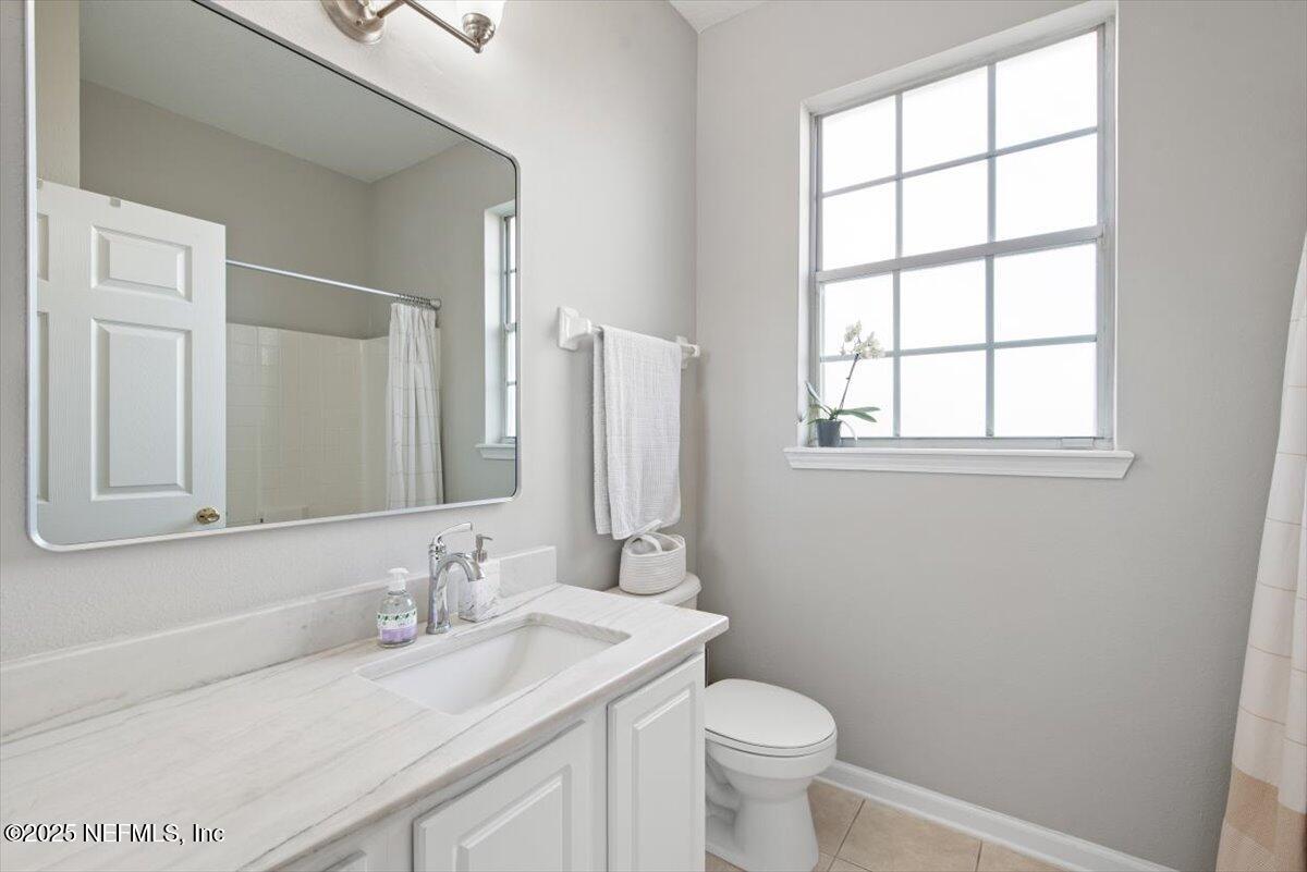 7990 Baymeadows Road East, Unit 913 Jacksonville, FL 32256 - Photo 36 of 70 a bathroom with a granite countertop sink toilet and mirror
