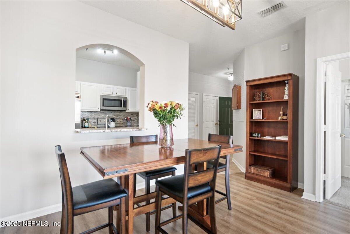7990 Baymeadows Road East, Unit 913 Jacksonville, FL 32256 - Photo 10 of 70 a view of a dining room with furniture and wooden floor