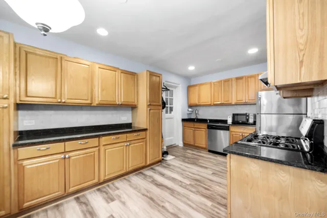 a kitchen with granite countertop cabinets stainless steel appliances and a window