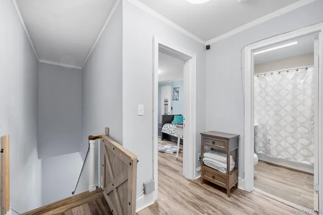 a view of a hallway with wooden floor and staircase