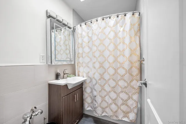 a bathroom with a sink a vanity and a shower curtain