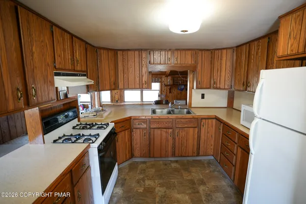 a kitchen with stainless steel appliances granite countertop a stove sink refrigerator and cabinets