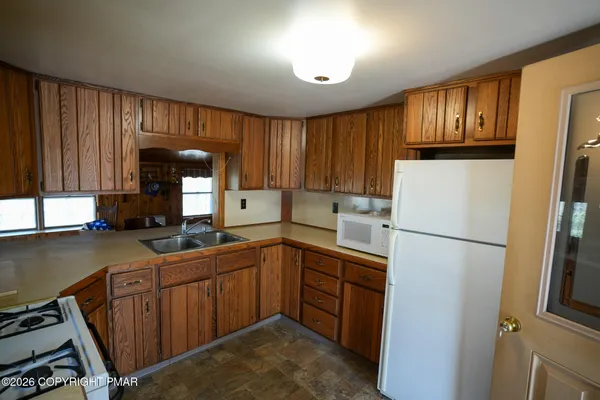 a kitchen with a sink a refrigerator and cabinets