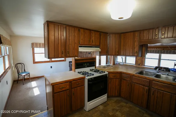 a kitchen with granite countertop a stove sink and cabinets