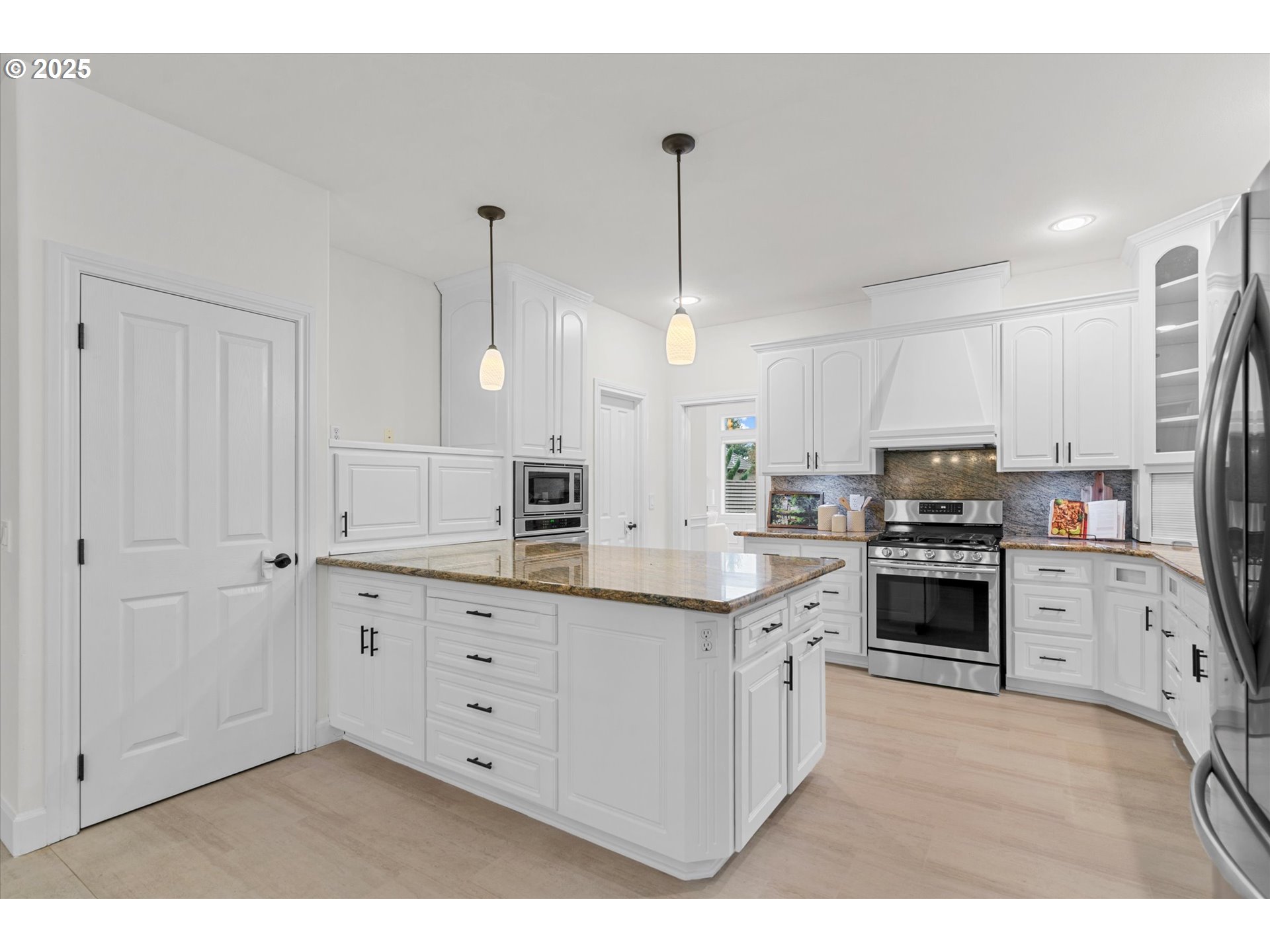 2711 Northwest 28th Circle Camas, WA 98607 - Photo 11 of 45 a kitchen with stainless steel appliances kitchen island granite countertop a stove a sink and a refrigerator