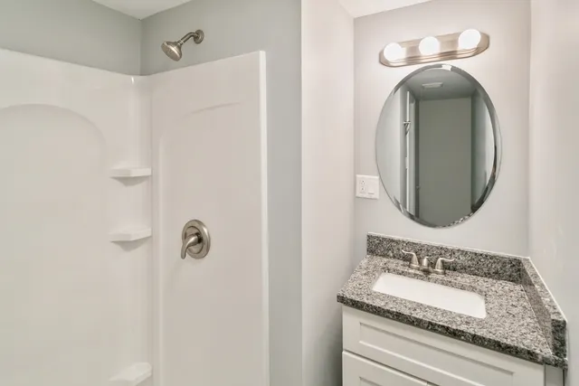 a bathroom with a granite countertop sink and a mirror