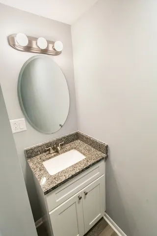 a bathroom with a granite countertop sink and mirror