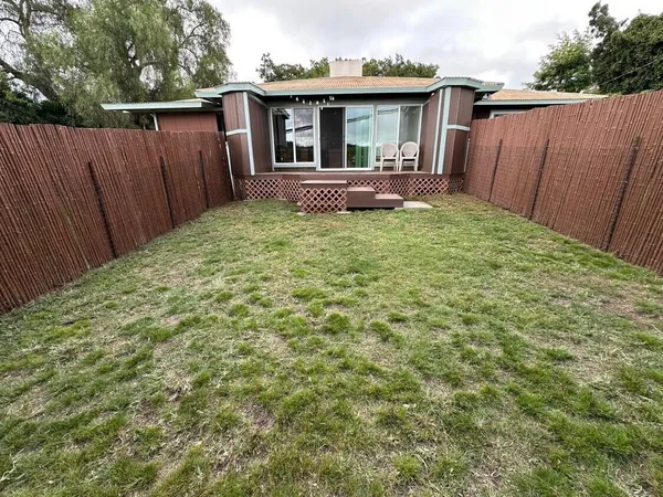 a view of a house with backyard and sitting area