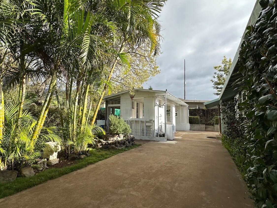 3135 Lower Kula Road Kula, HI 96790 - Photo 17 of 30 a front view of a house with a yard and potted plants