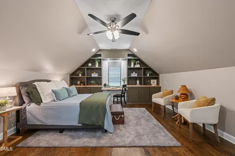 a spacious bedroom with a bed a chandelier and a couch