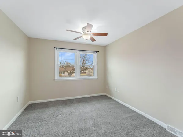 an empty room with a window and a ceiling fan