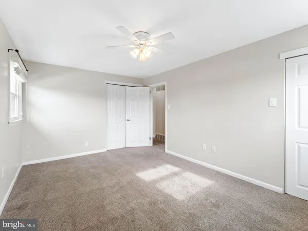 a view of an empty room with a chandelier fan
