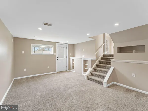 an empty room with wooden floor and white walls