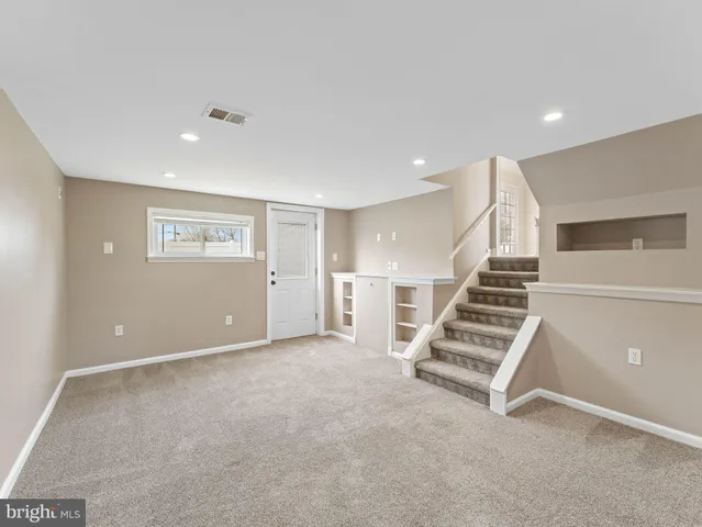 an empty room with wooden floor and white walls