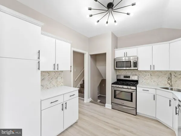 a kitchen with stainless steel appliances white cabinets and a sink