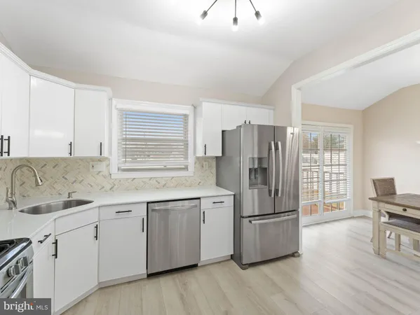 a kitchen with a refrigerator sink and cabinets