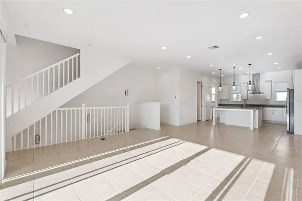 a living room with stainless steel appliances furniture and a kitchen view