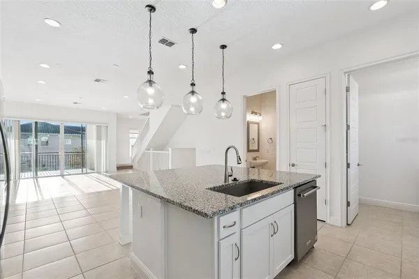 a kitchen with stainless steel appliances granite countertop a sink a counter space and a window