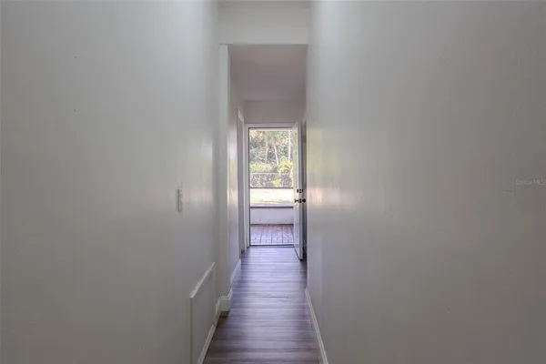 a view of a hallway with wooden floor
