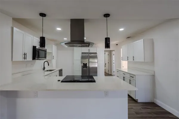 a kitchen with kitchen island a counter top space appliances and cabinets