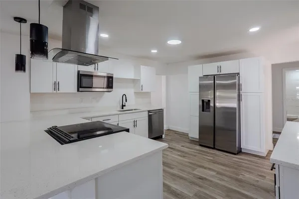 a kitchen with stainless steel appliances a refrigerator sink and stove