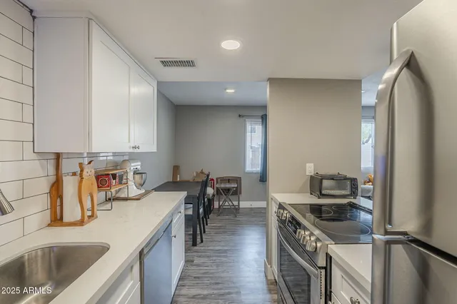 a kitchen with stainless steel appliances a refrigerator and a stove