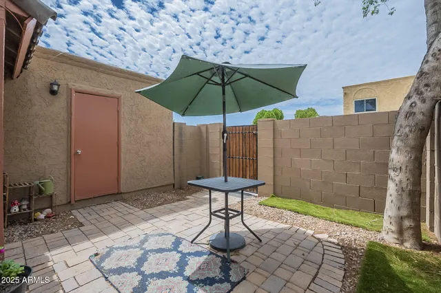 a view of a backyard with furniture and umbrella