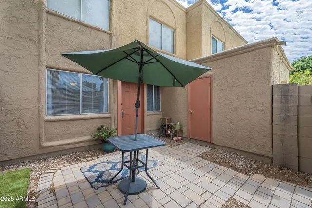 a backyard of a house with table and chairs