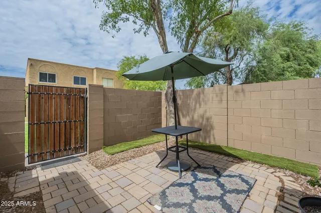 a backyard of a house with table and chairs