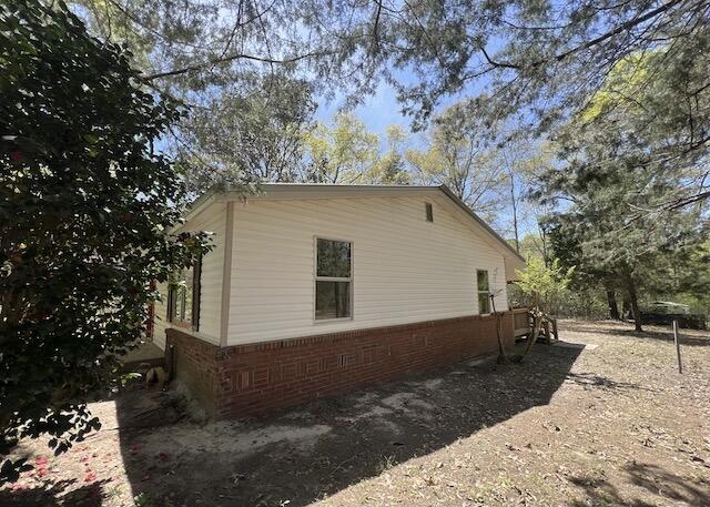 8106 County Line Road Laurel Hill, FL 32567 - Photo 11 of 13 a backyard of a house with large trees and wooden fence