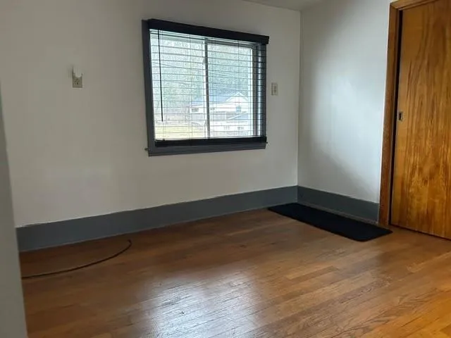 an empty room with windows and closet