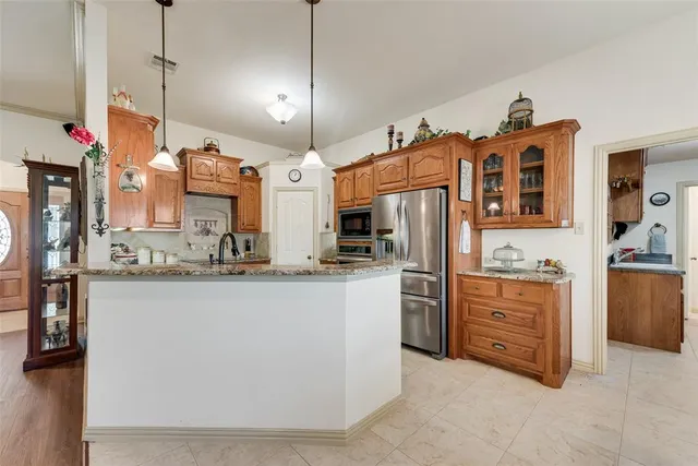 a kitchen with refrigerator and cabinets
