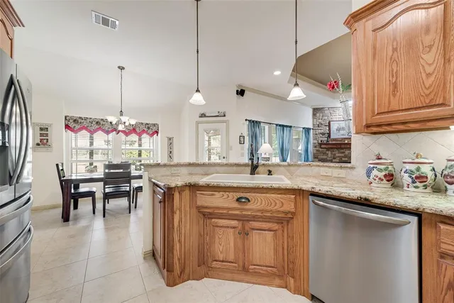 a kitchen with a sink a counter space appliances and cabinets
