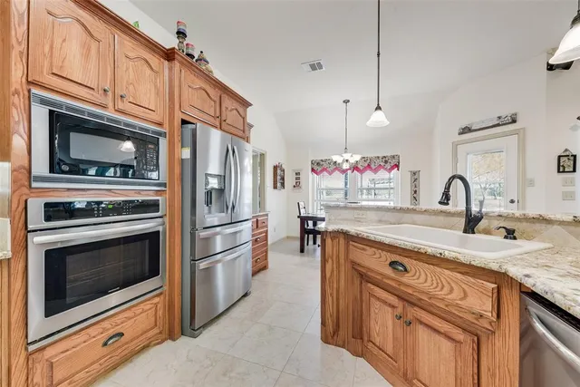 a kitchen with stainless steel appliances granite countertop a stove microwave and a sink