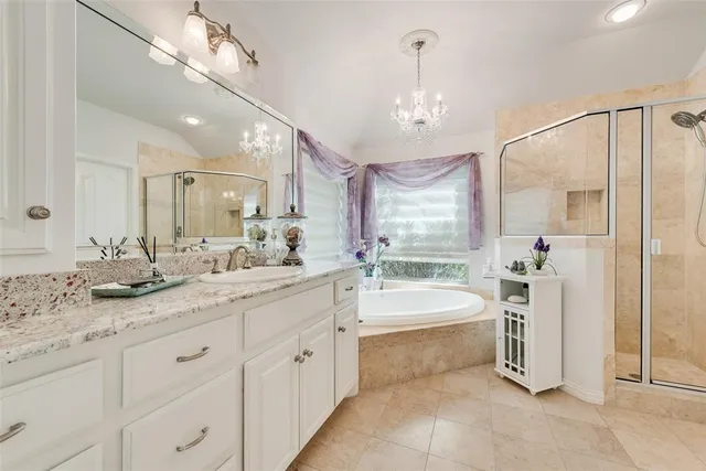a spacious bathroom with a double vanity sink a mirror a bathtub and shower