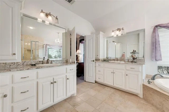 a bathroom with a granite countertop sink double vanity and a mirror