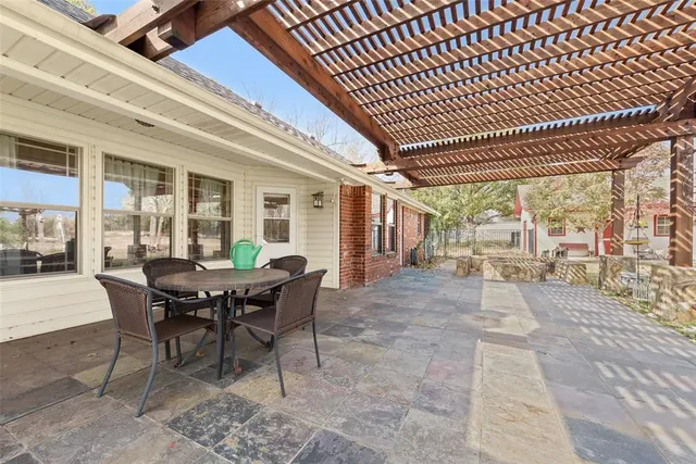 a view of a patio with table and chairs and floor to ceiling window