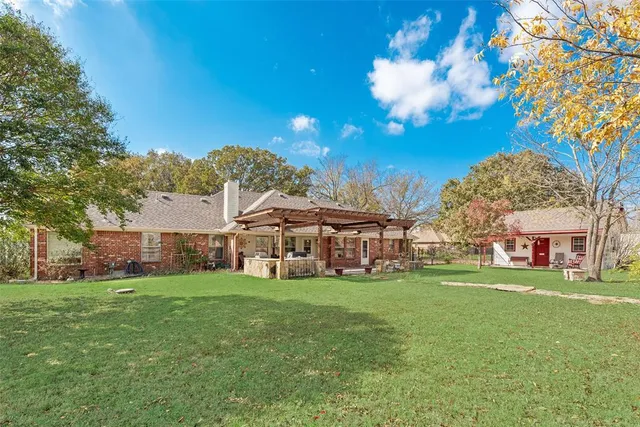 a view of a house with a big yard and large trees