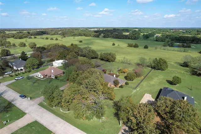 an aerial view of a houses with a yard
