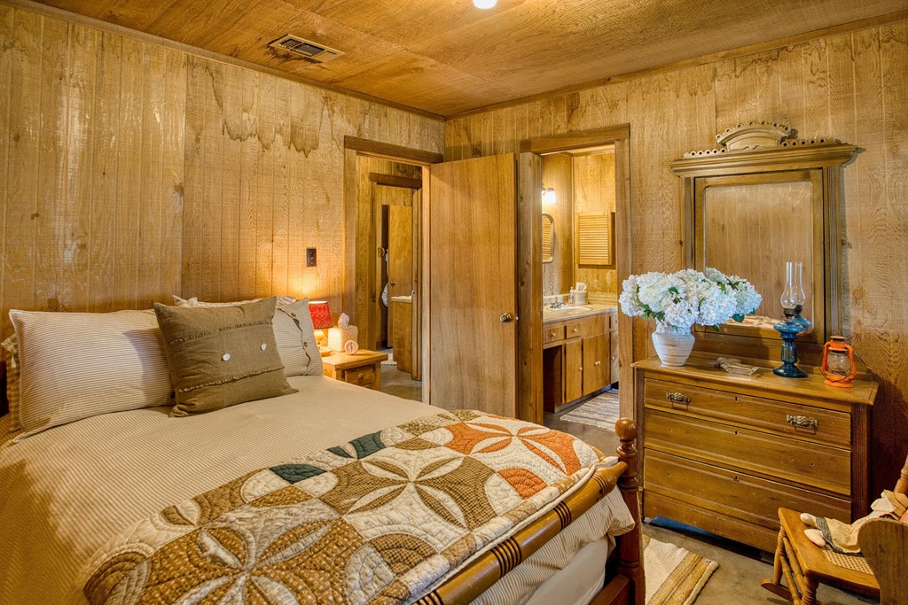 7461 Triplet Mill Road Mason, TX 76856 - Photo 33 of 46 a bedroom with a bed and wooden floor