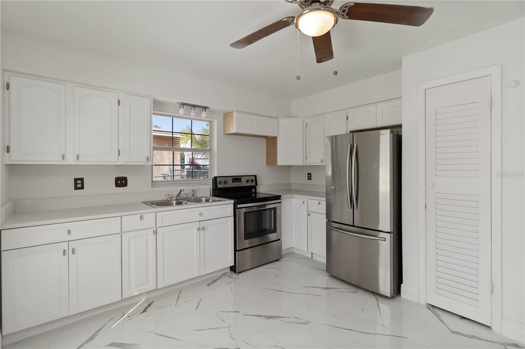 114 Palencia Road Auburndale, FL 33823 - Photo 12 of 27 a kitchen with white cabinets and stainless steel appliances