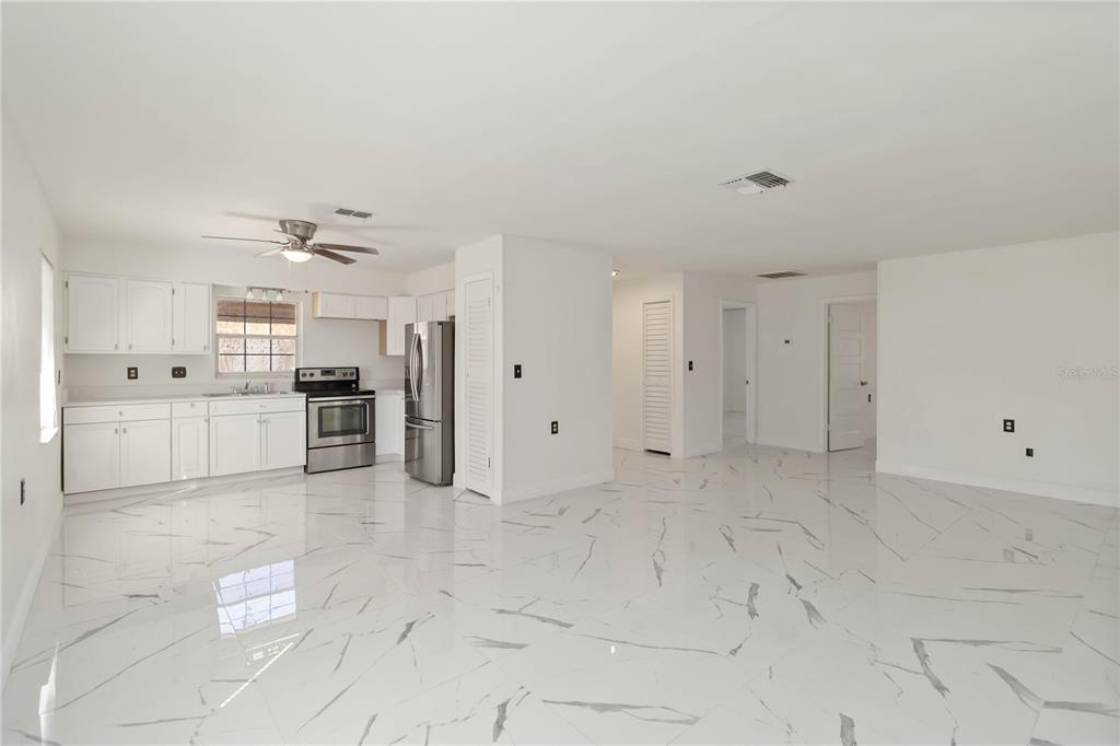 114 Palencia Road Auburndale, FL 33823 - Photo 9 of 27 a view of a kitchen with refrigerator and white cabinets