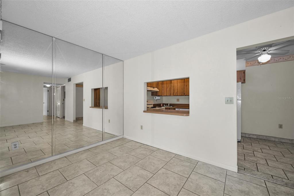 2687 Pine Ridge Way South, Unit B2 Palm Harbor, FL 34684 - Photo 17 of 68 a view of a hallway with wooden floor and chandelier