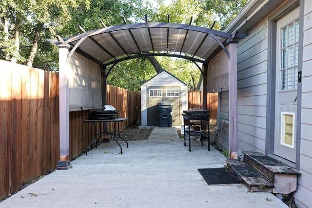 a view of a chairs and table in the patio next to a yard