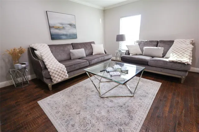 a living room with furniture and wooden floor