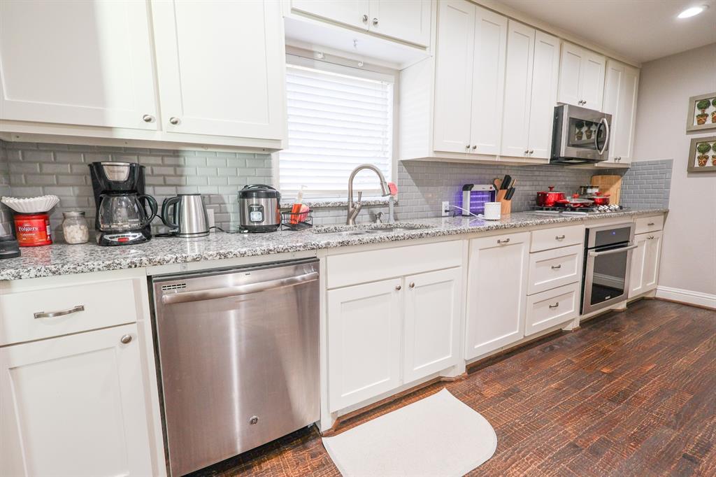 605 East Graham Street McKinney, TX 75069 - Photo 8 of 22 a kitchen with granite countertop white cabinets and white appliances